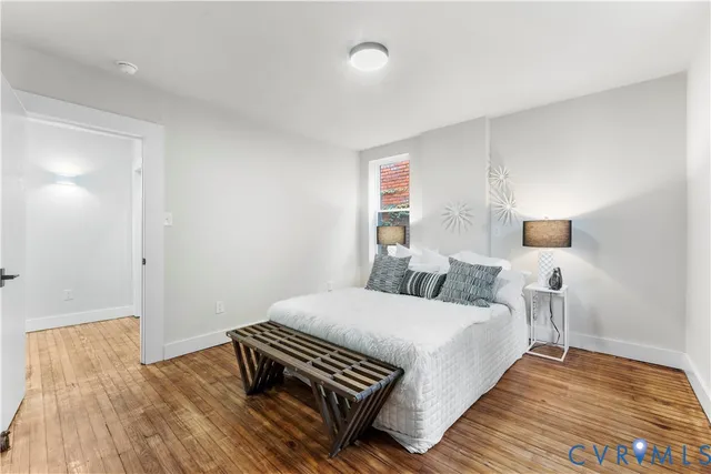 a bedroom with a bed and wooden floor