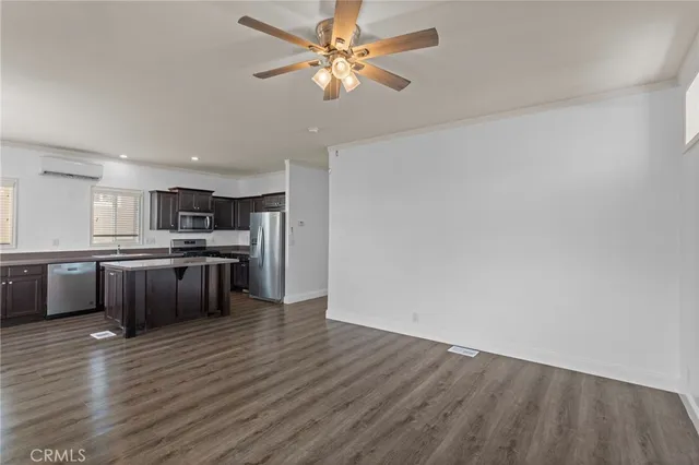 a large kitchen with a wooden floor and stainless steel appliances