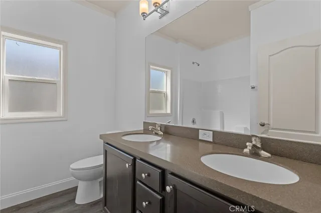 a bathroom with a granite countertop sink a toilet and a mirror