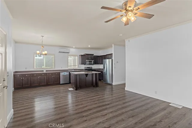 a large kitchen with a wooden floor and stainless steel appliances