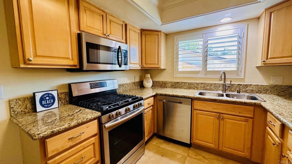 1034 Turnstone Way Oceanside, CA 92057 - Photo 7 of 28 a kitchen with stainless steel appliances granite countertop a sink stove and microwave