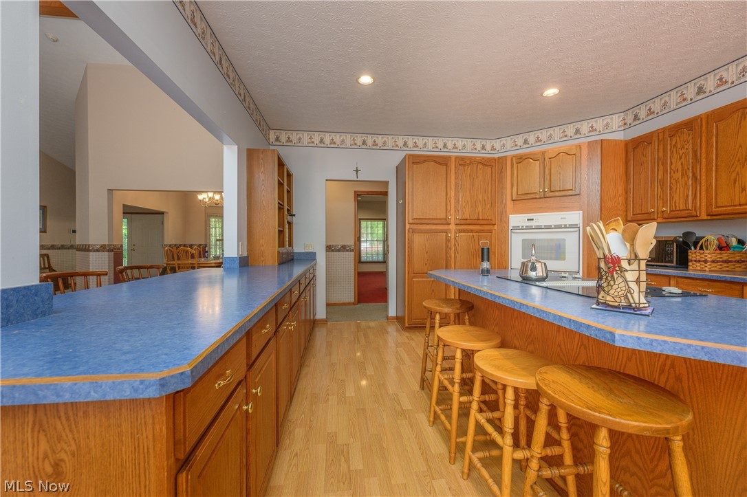 8745 Broadview Road Broadview Heights, OH 44147 - Photo 8 of 49 Spacious kitchen featuring extensive wood cabinetry, blue countertops, and wood-finish flooring
