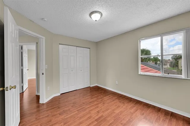 a view of a big room with wooden floor and windows