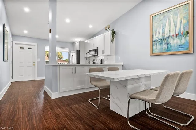 a large kitchen with kitchen island a sink dishwasher a stove and a refrigerator with wooden floor