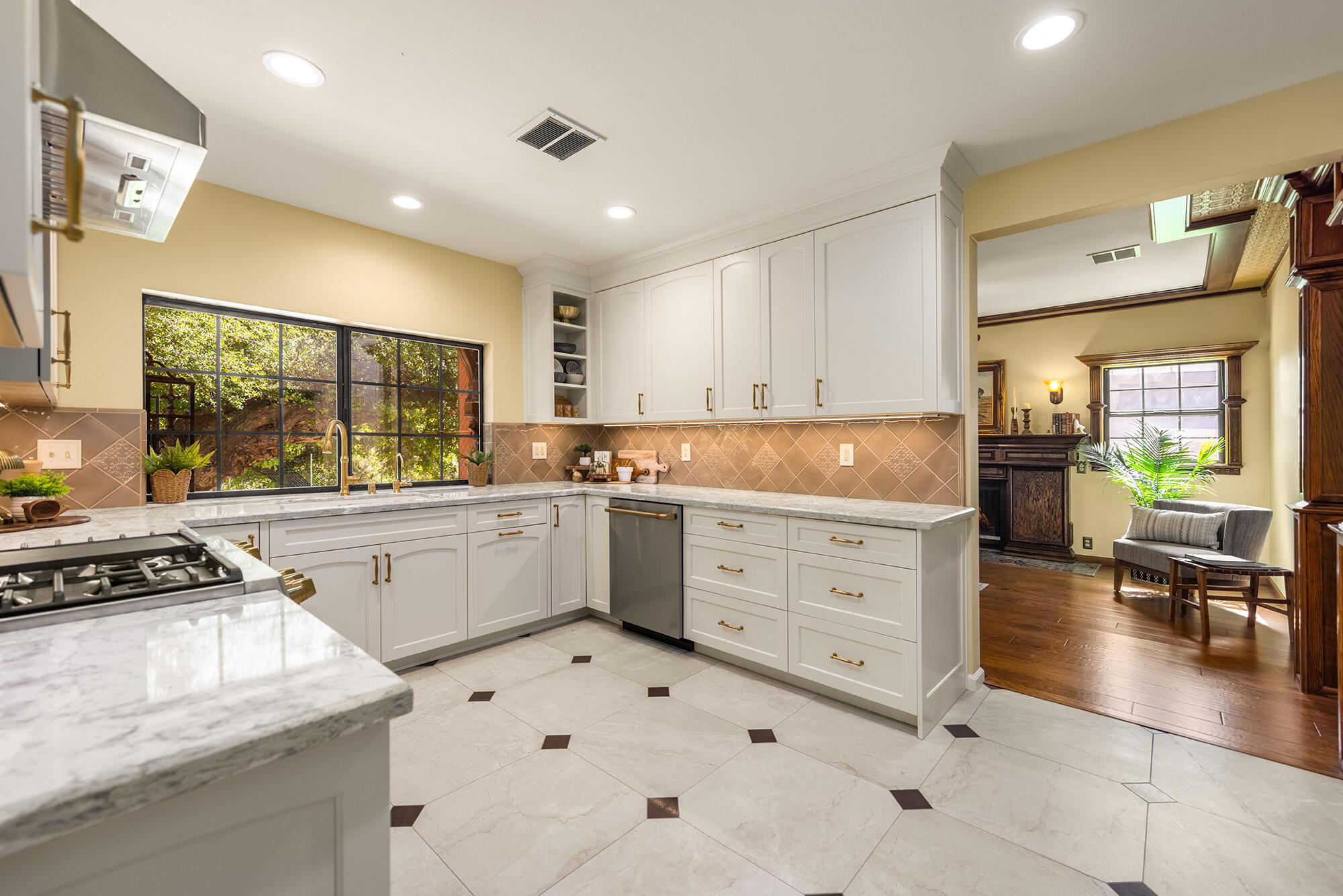 10480 Creek Road Oak View, CA 93022 - Photo 15 of 52 a kitchen with granite countertop a stove a sink and white cabinets with wooden floor