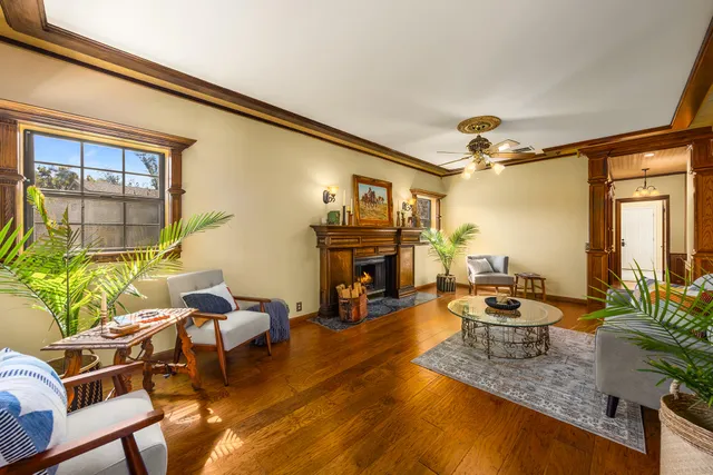 a living room with fireplace furniture and a large window