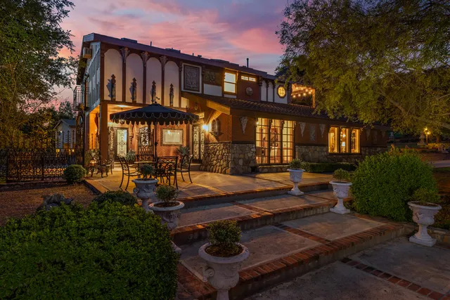 a view of a house with backyard and sitting area