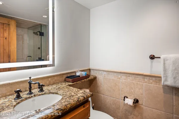 a bathroom with a granite countertop sink and a mirror