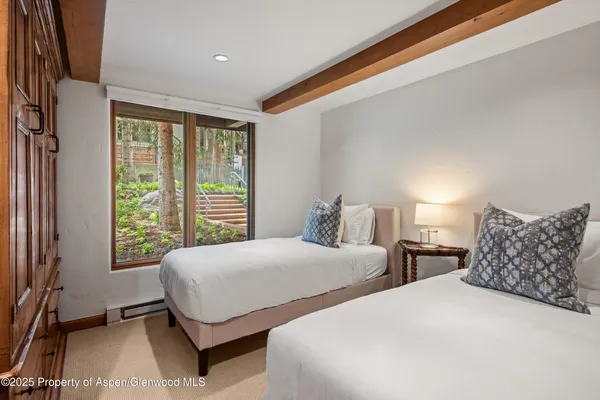 a bedroom with two beds and a large window