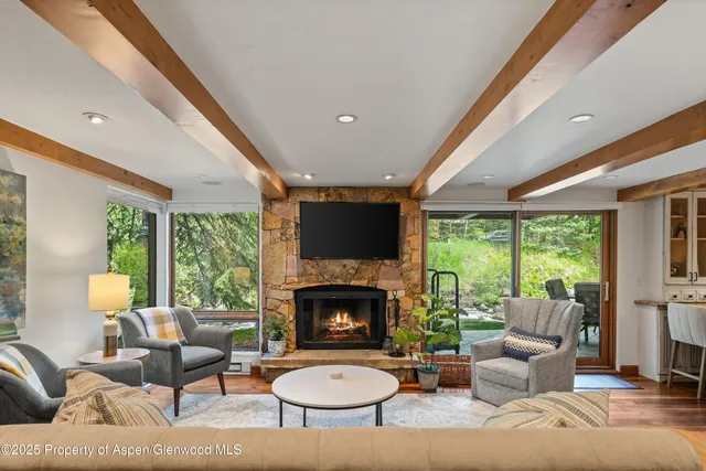 a living room with furniture a large window and a fireplace