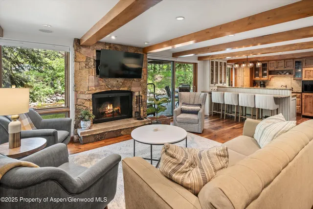 a living room with furniture a fireplace and a floor to ceiling window
