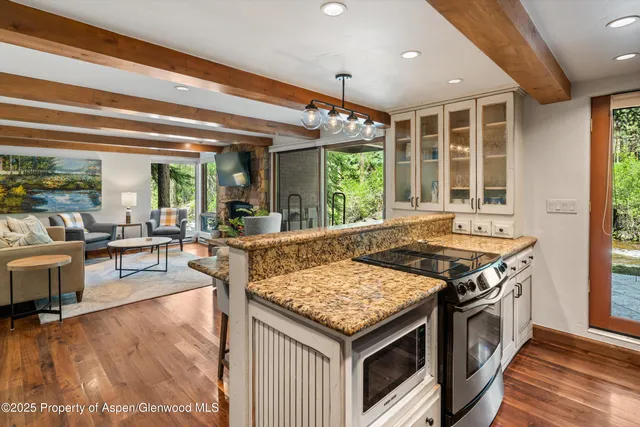 a kitchen with a stove and a view of living room