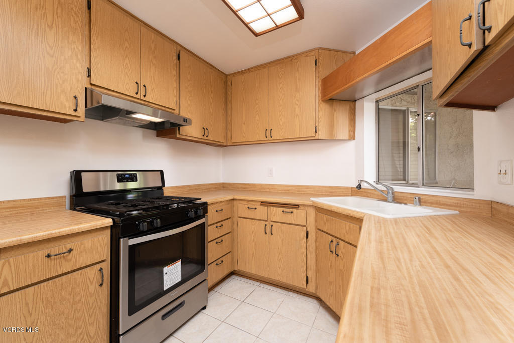 1730 Sinaloa Road, Unit 312 Simi Valley, CA 93065 - Photo 7 of 24 a kitchen with stainless steel appliances granite countertop a stove a sink and a white cabinets