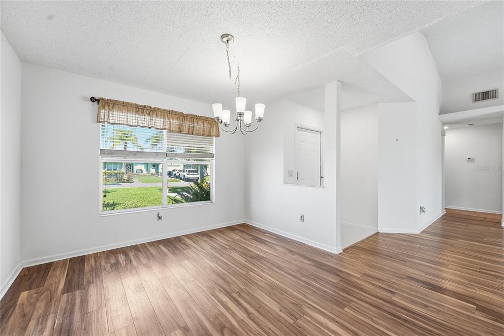 5930 Foxtail Way Fort Pierce, FL 34982 - Photo 13 of 47 a view of an empty room with wooden floor and a window