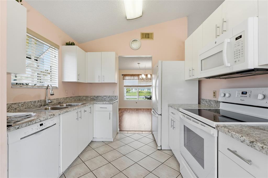 5930 Foxtail Way Fort Pierce, FL 34982 - Photo 9 of 47 a kitchen with granite countertop a sink and cabinets