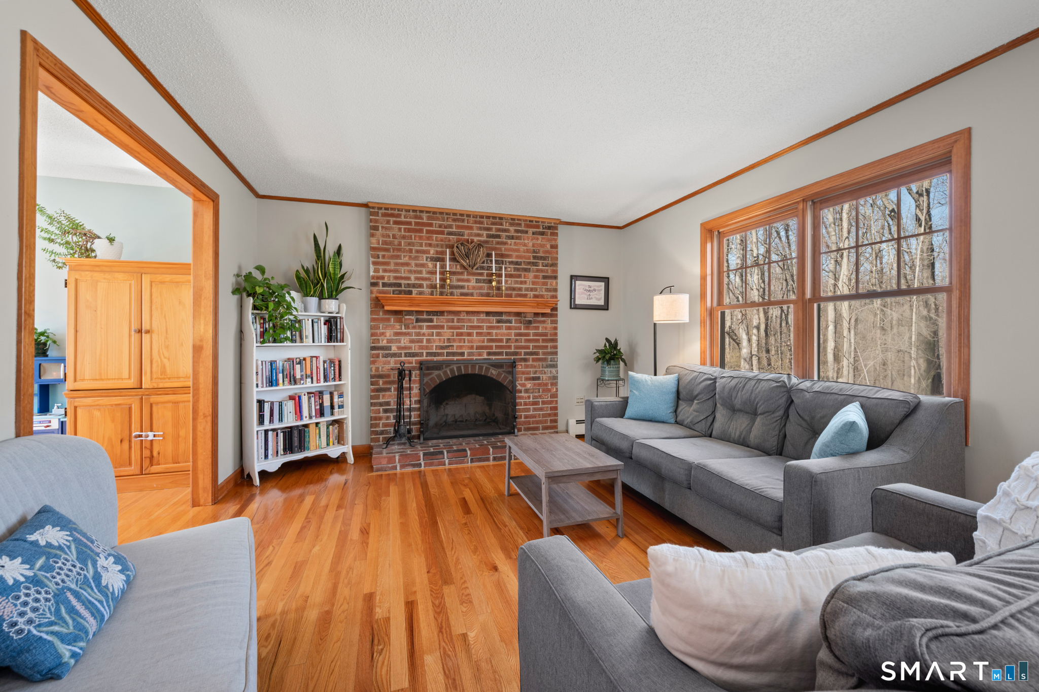 16 Gardner Tavern Road Coventry, CT 06238 - Photo 8 of 40 The wood burning brick fireplace is the focal point of the living room. Hardwood flooring seamlessly connects the living room and home office