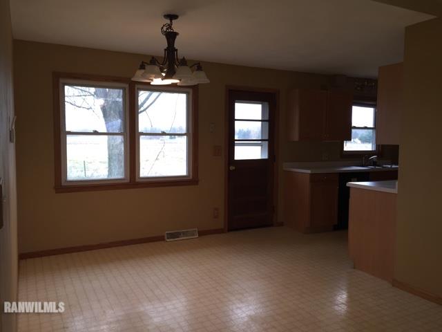 12995 Center Road Durand, IL 61024 - Photo 5 of 14 an empty room with windows and chandelier fan