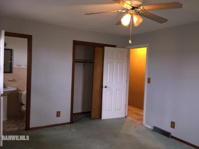 12995 Center Road Durand, IL 61024 - Photo 9 of 14 an empty room with a chandelier fan and a bathroom