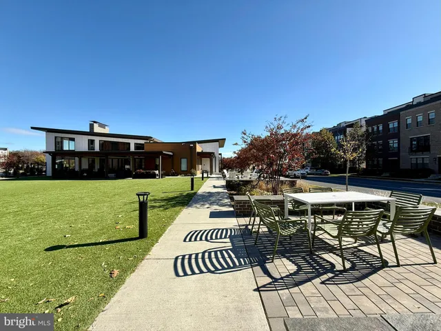 a view of a patio with couches table and chairs under an umbrella with a barbeque