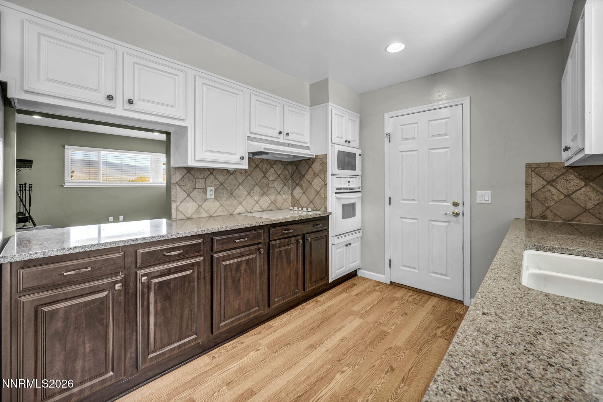 14190 Rim Rock Drive Reno, NV 89521 - Photo 21 of 68 a kitchen with granite countertop wooden cabinets and white appliances