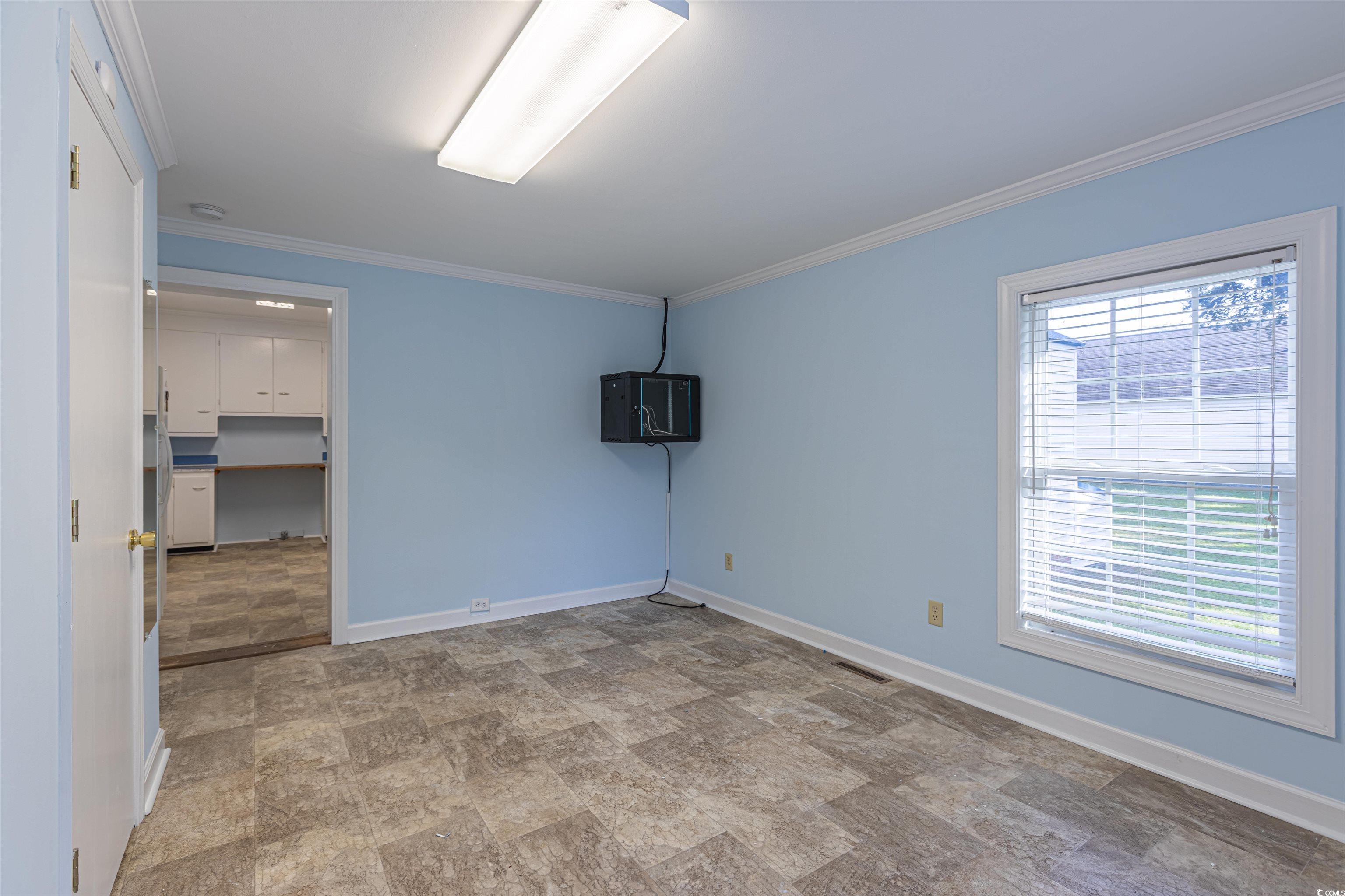 505 North Longstreet Street Kingstree, SC 29556 - Photo 14 of 34 Empty room with ornamental molding and stone finish flooring