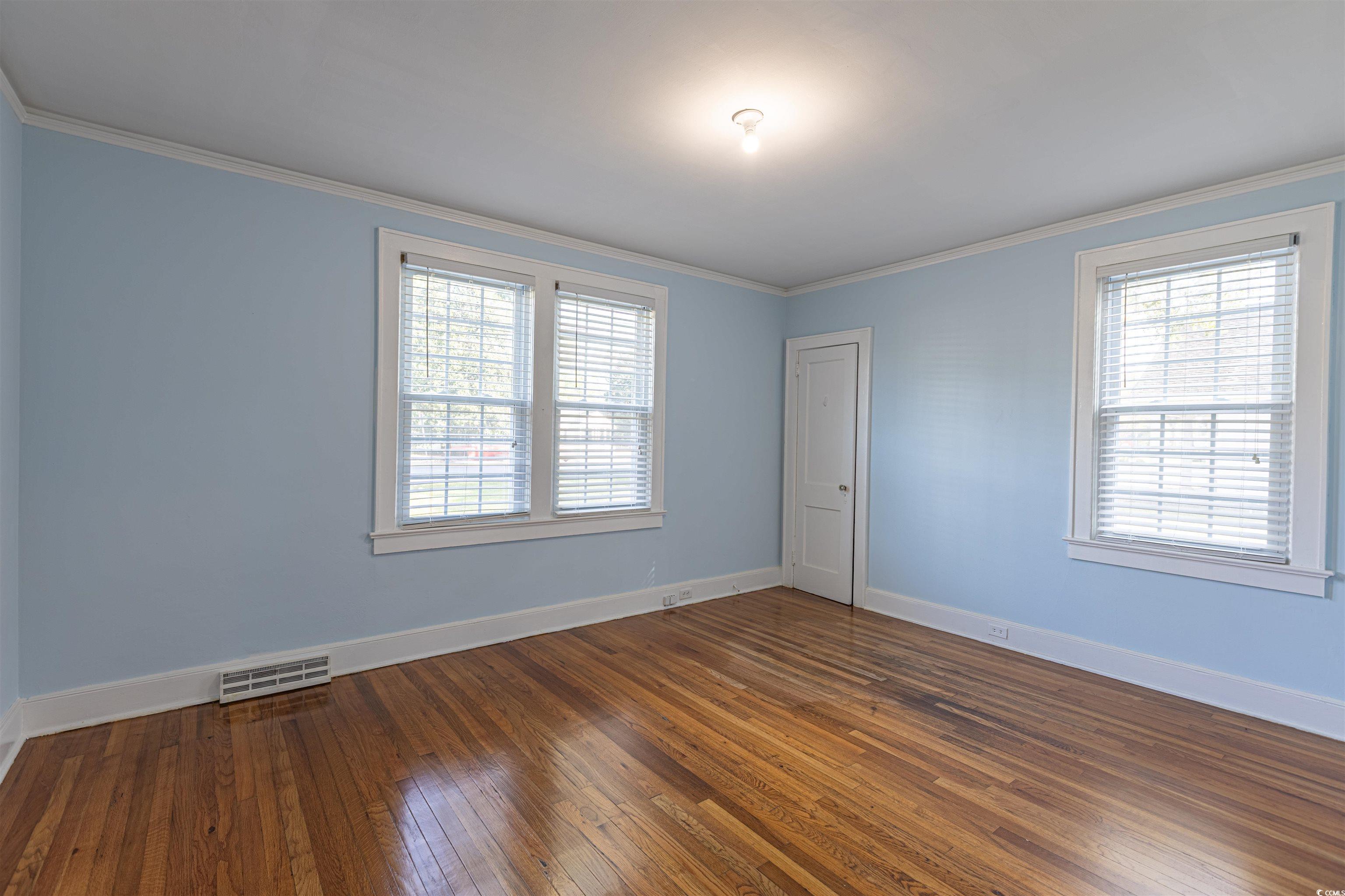 505 North Longstreet Street Kingstree, SC 29556 - Photo 17 of 34 Spare room with dark wood-type flooring, ornamental molding, and healthy amount of natural light