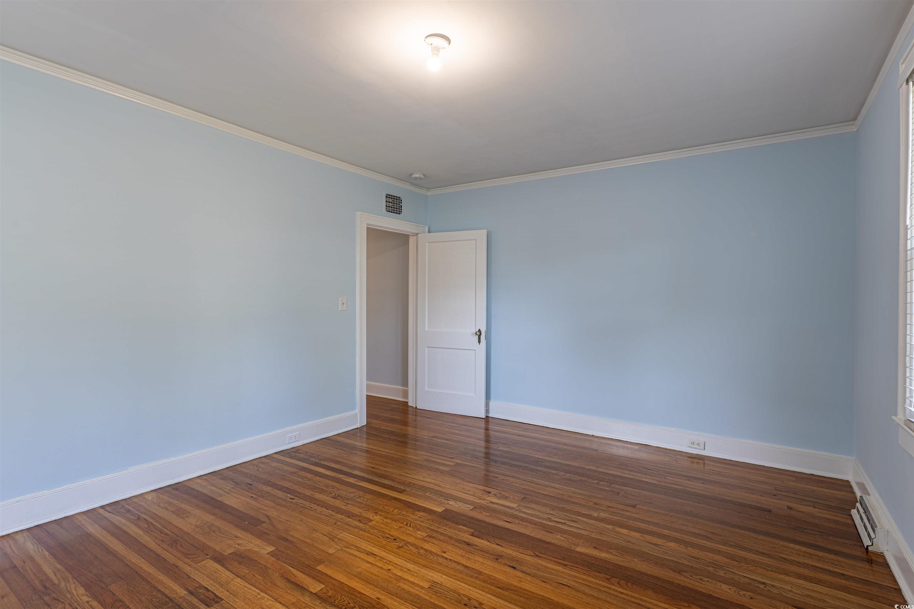 505 North Longstreet Street Kingstree, SC 29556 - Photo 18 of 34 Empty room featuring dark wood finished floors and ornamental molding