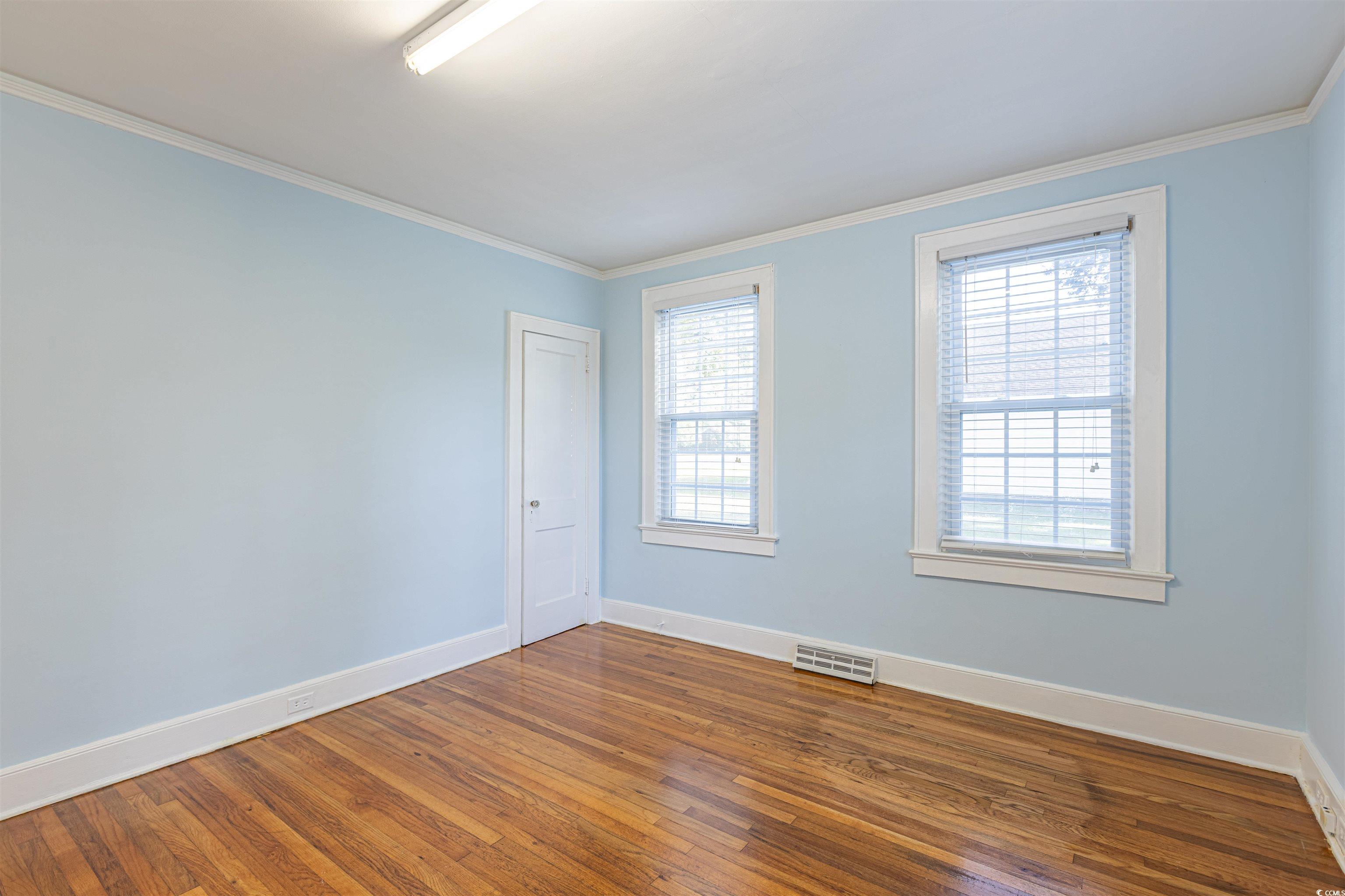 505 North Longstreet Street Kingstree, SC 29556 - Photo 20 of 34 Empty room featuring hardwood / wood-style flooring and crown molding