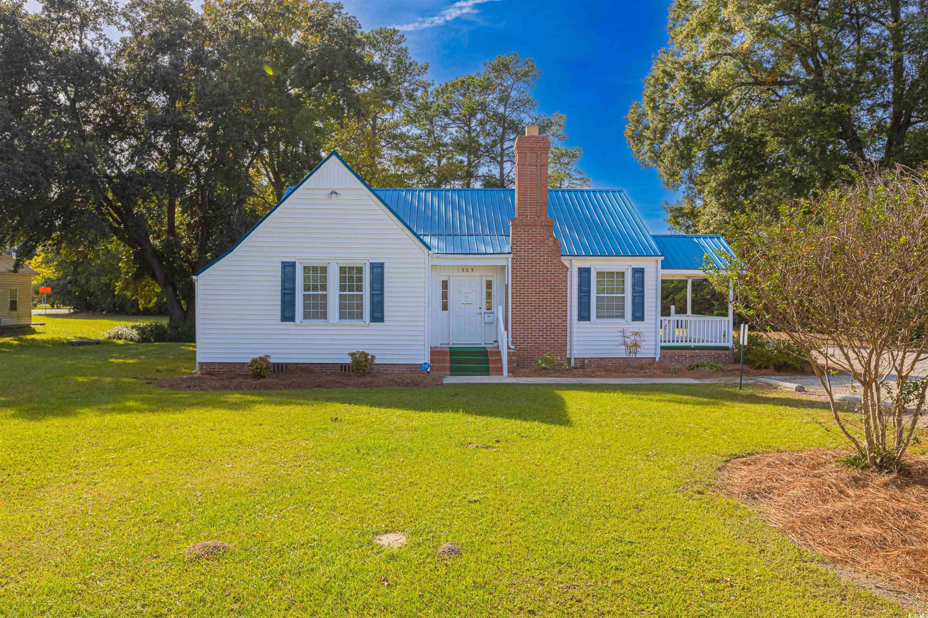 505 North Longstreet Street Kingstree, SC 29556 - Photo 2 of 34 View of front of house featuring a front yard, a chimney, a metal roof, and crawl space