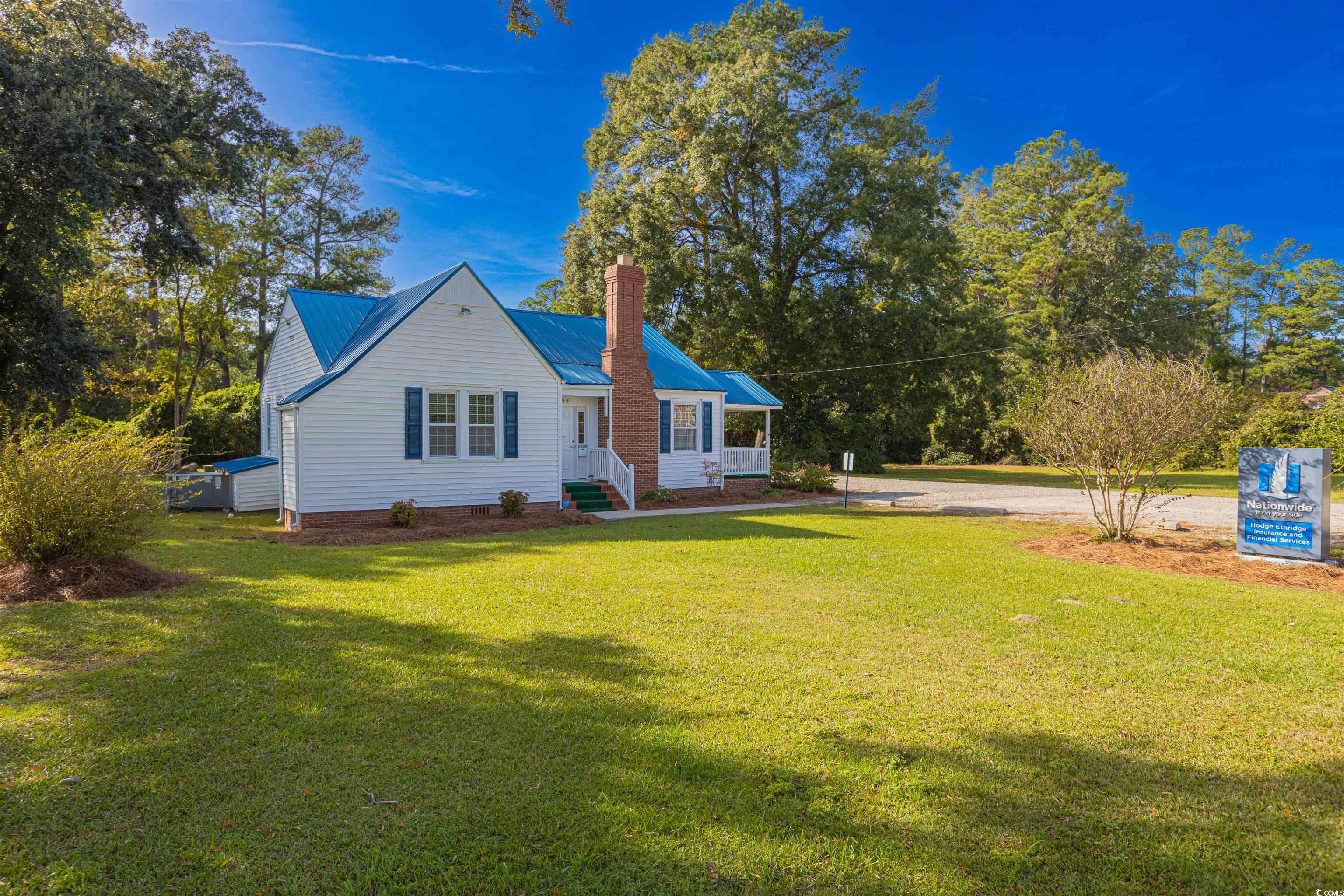 505 North Longstreet Street Kingstree, SC 29556 - Photo 23 of 34 View of front of house featuring a front lawn, a metal roof, and a chimney