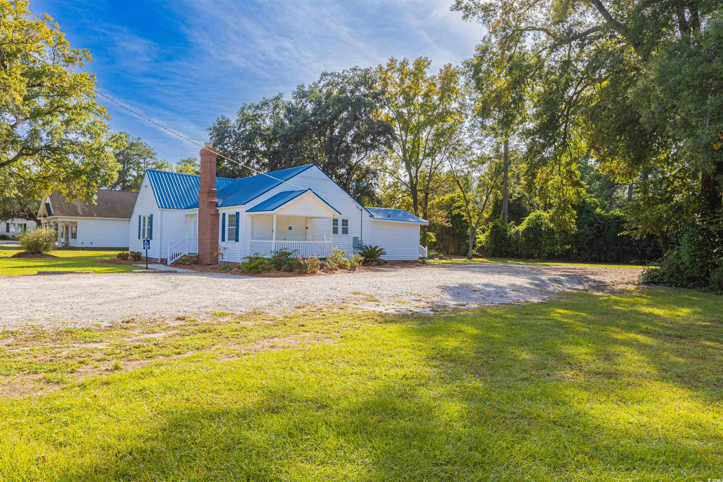 505 North Longstreet Street Kingstree, SC 29556 - Photo 25 of 34 View of property exterior with a lawn, a chimney, a metal roof, and a porch