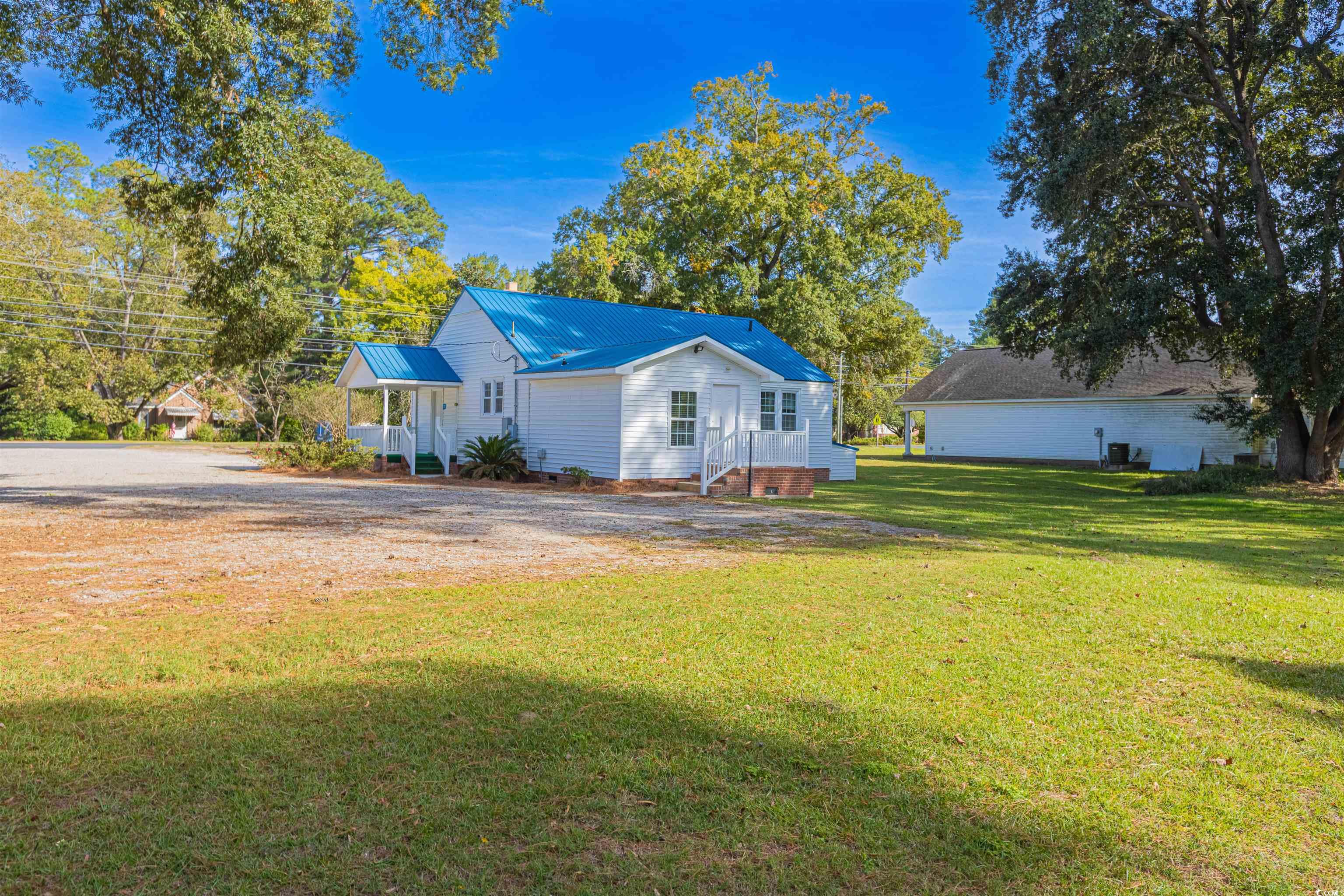 505 North Longstreet Street Kingstree, SC 29556 - Photo 28 of 34 Rear view of property with a metal roof and a lawn