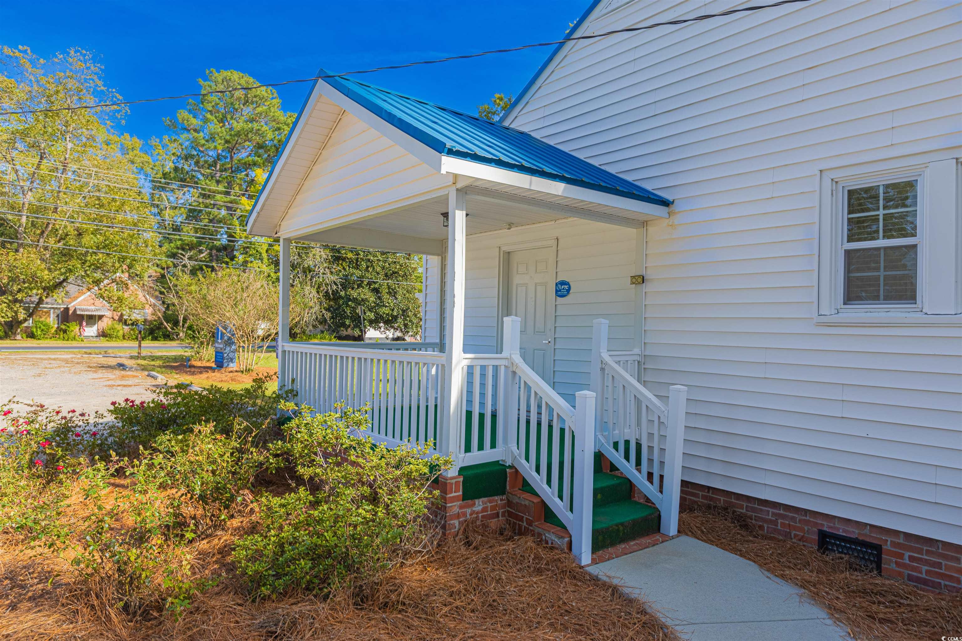 505 North Longstreet Street Kingstree, SC 29556 - Photo 33 of 34 Doorway to property featuring covered porch, crawl space, and a metal roof