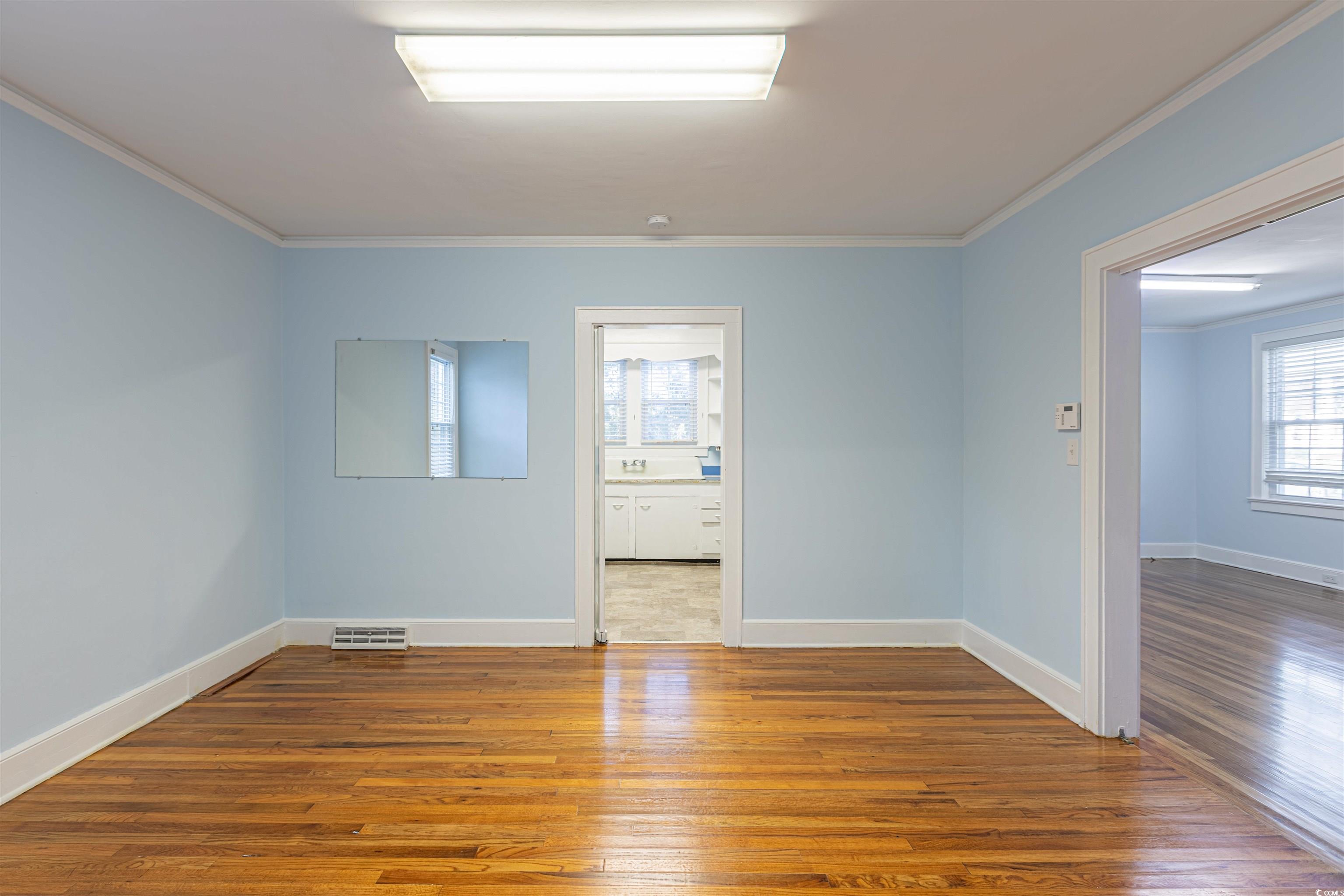 505 North Longstreet Street Kingstree, SC 29556 - Photo 8 of 34 Unfurnished room featuring wood-type flooring and ornamental molding