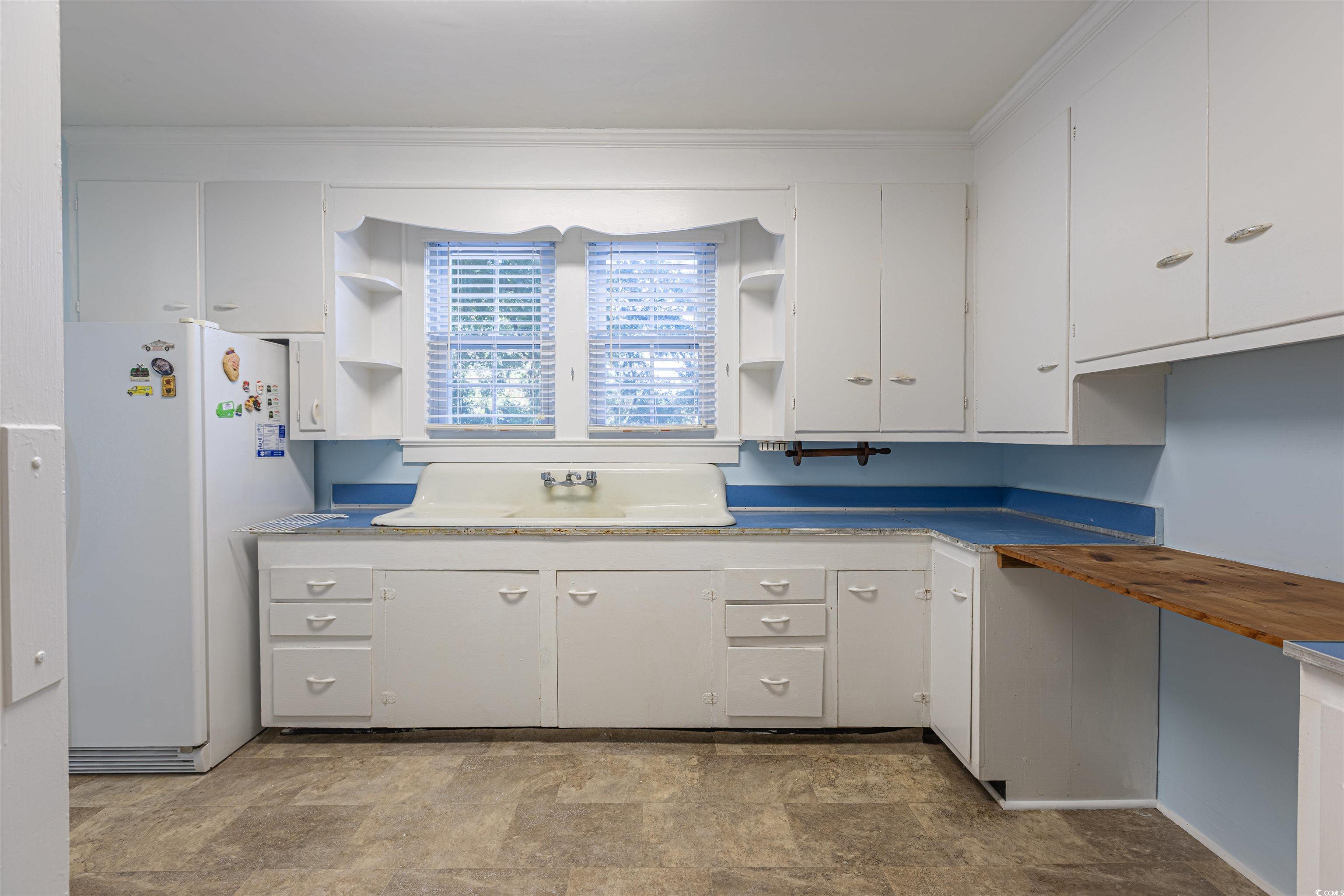 505 North Longstreet Street Kingstree, SC 29556 - Photo 10 of 34 Kitchen featuring open shelves, freestanding refrigerator, stone finish flooring, and white cabinetry