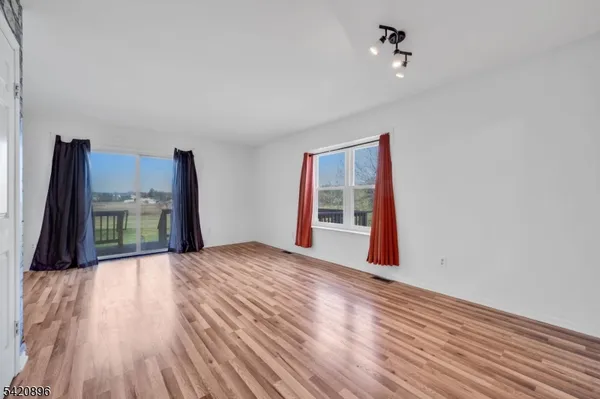 a view of a livingroom with wooden floor and a ceiling fan