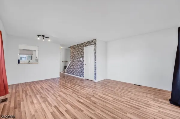 a view of a room with wooden floor and white walls