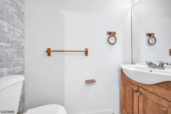 a bathroom with a sink a toilet a mirror and vanity