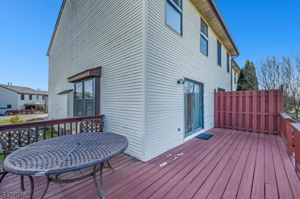 a view of a house with wooden deck and furniture