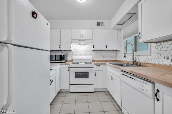a kitchen with a white cabinets and white appliances