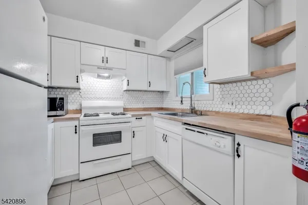 a kitchen with granite countertop white cabinets and white appliances