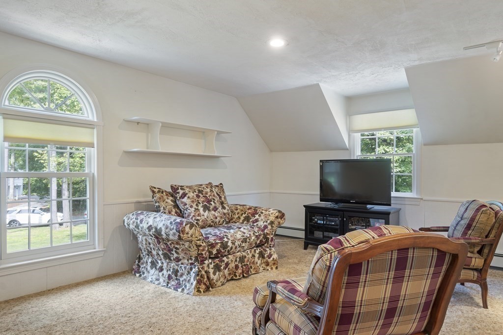 57 Surrey Lane Boxford, MA 01921 - Photo 19 of 42 a living room with furniture a flat screen tv and a floor to ceiling window