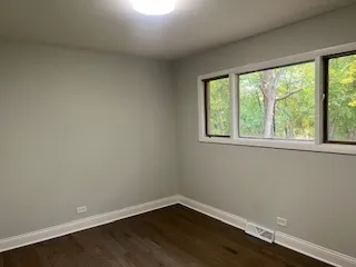 a view of a small space with wooden floor and a window