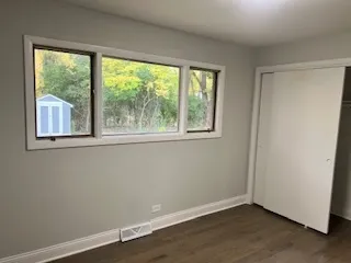 an empty room with wooden floor and a window