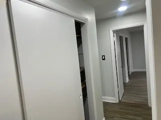 a view of a hallway with wooden floor and staircase