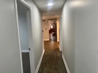 a view of a hallway with wooden floor