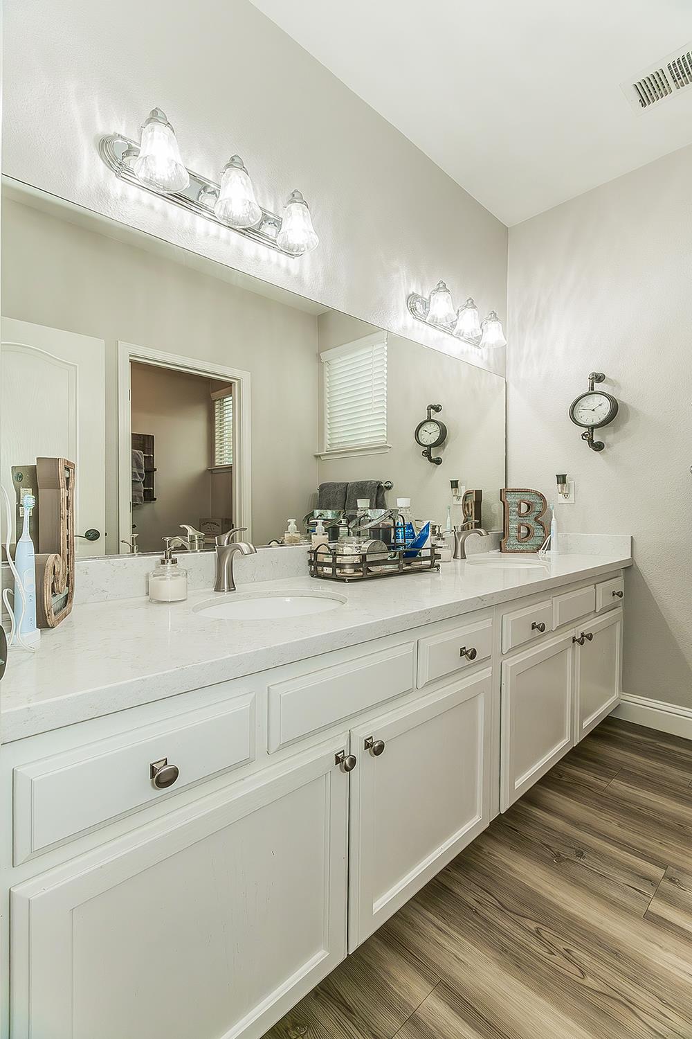 1175 Applegate Avenue Clovis, CA 93611 - Photo 31 of 65 a bathroom with a double vanity sink and a mirror