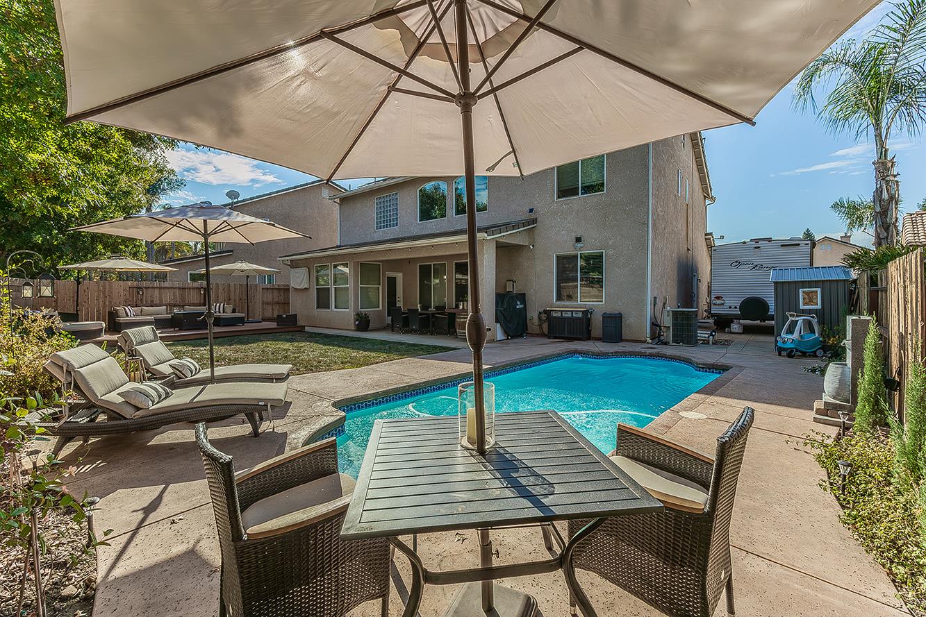 1175 Applegate Avenue Clovis, CA 93611 - Photo 41 of 65 a view of a patio with table and chairs under an umbrella