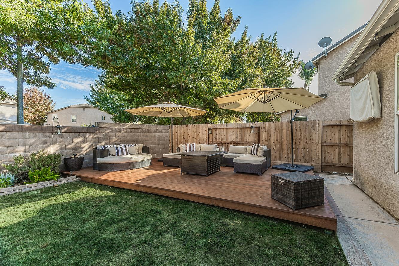 1175 Applegate Avenue Clovis, CA 93611 - Photo 43 of 65 a view of a patio with chairs and a table and chairs under an umbrella