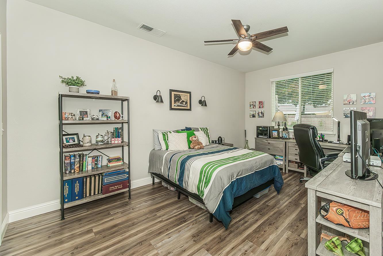 1175 Applegate Avenue Clovis, CA 93611 - Photo 49 of 65 a bedroom with a bed a bookshelf and a chandelier